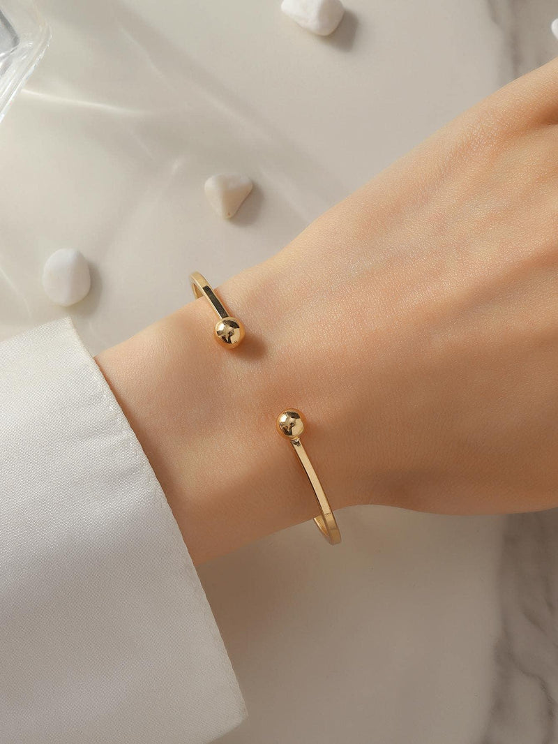 Bracciale rigido con decorazione a sfera color oro, eleganza chic quotidiana